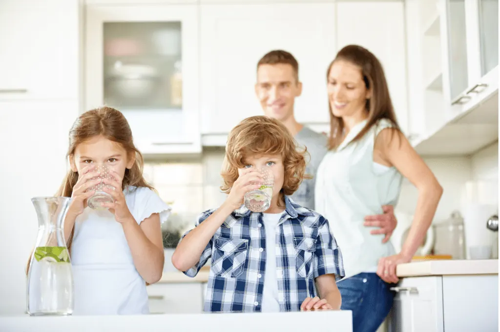 Familia bebiendo agua en la cocina